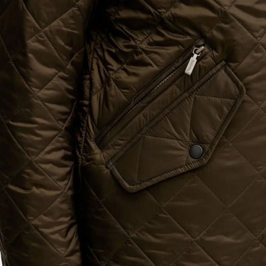 Close-up of a brown quilted jacket with a zipper pocket.