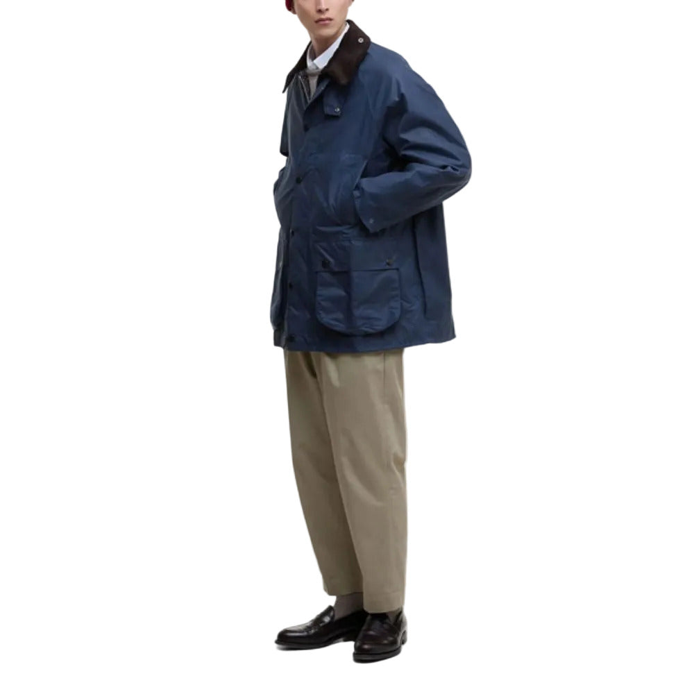 Person wearing a blue jacket and beige pants on a white background