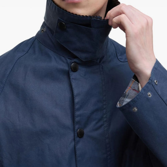 Person wearing a blue jacket with a close-up of the collar and buttons.