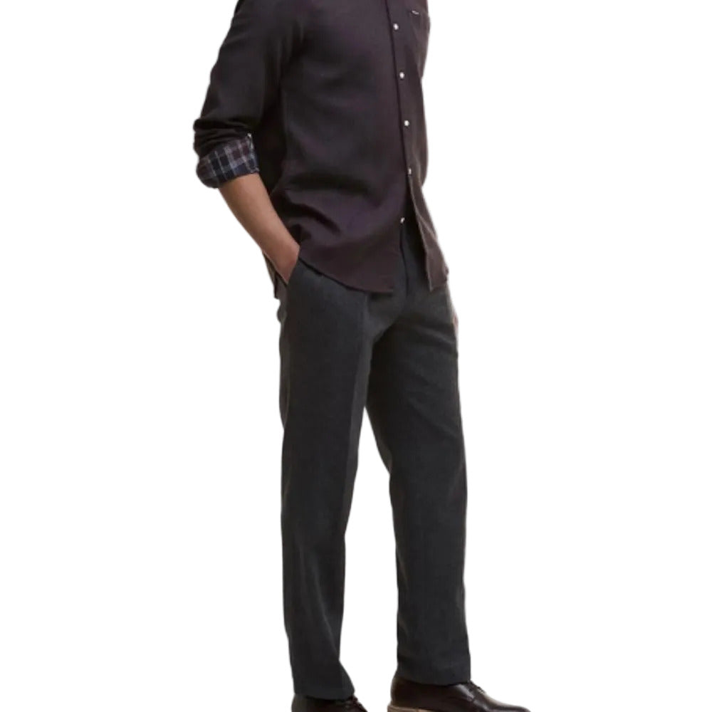 Person wearing a dark shirt and gray pants on a white background