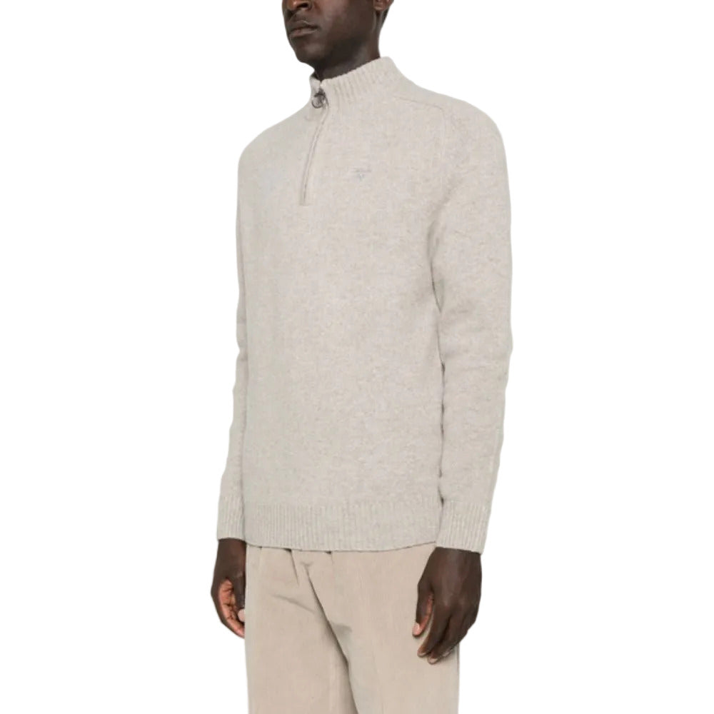 Man wearing a light gray half-zip sweater and beige pants on a white background