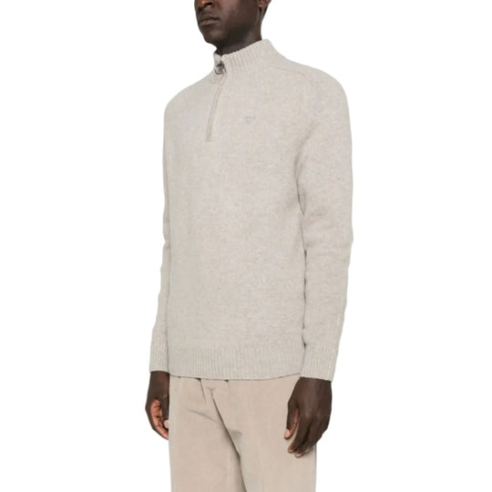 Man wearing a light gray half-zip sweater and beige pants on a white background