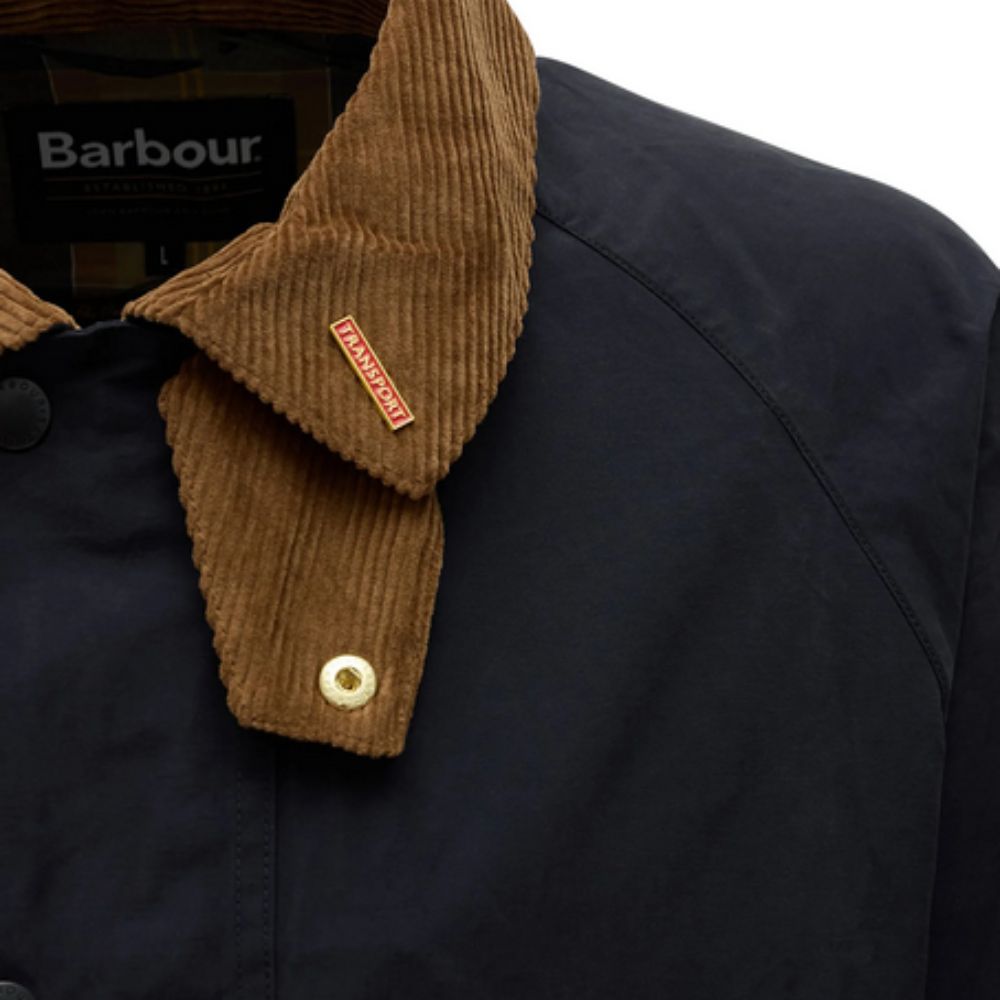 Close-up of a Barbour jacket with a brown collar and visible brand logo.