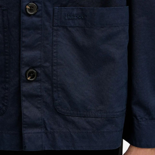 Navy blue jacket with a pocket and button detail, featuring the Barbour brand.