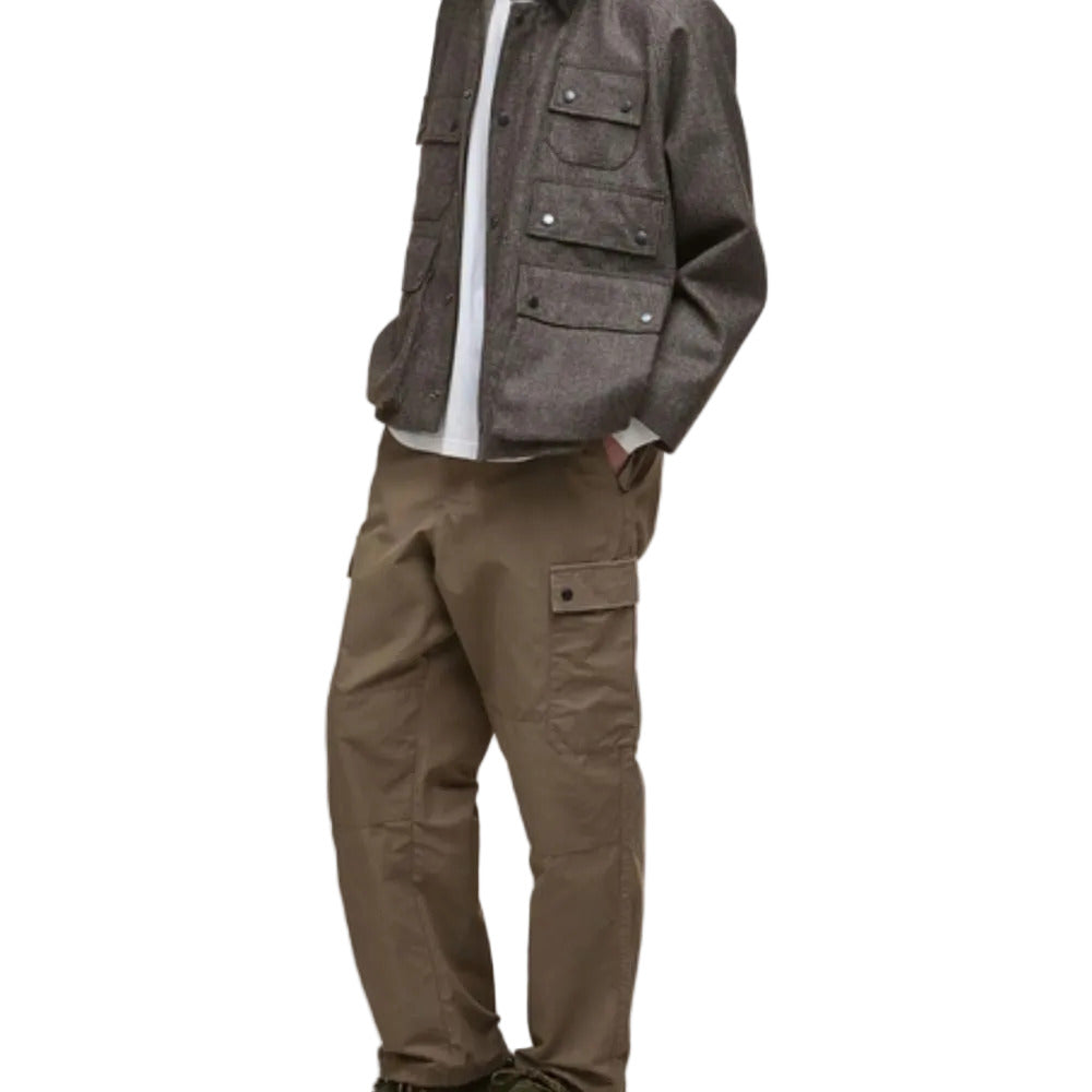 Person wearing a gray jacket and brown pants on a white background