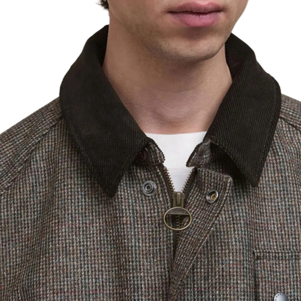 Close-up of a person wearing a brown checkered jacket with a black collar.