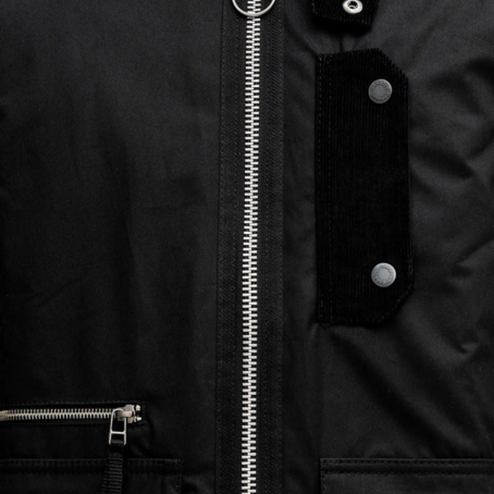 Close-up of a black jacket with a zipper and buttons.