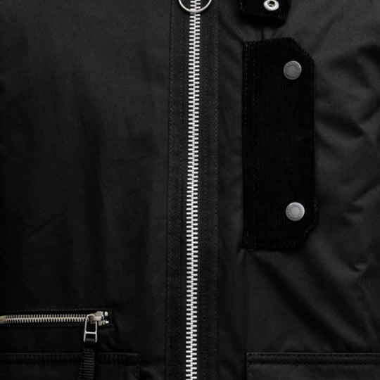 Close-up of a black jacket with a zipper and buttons.