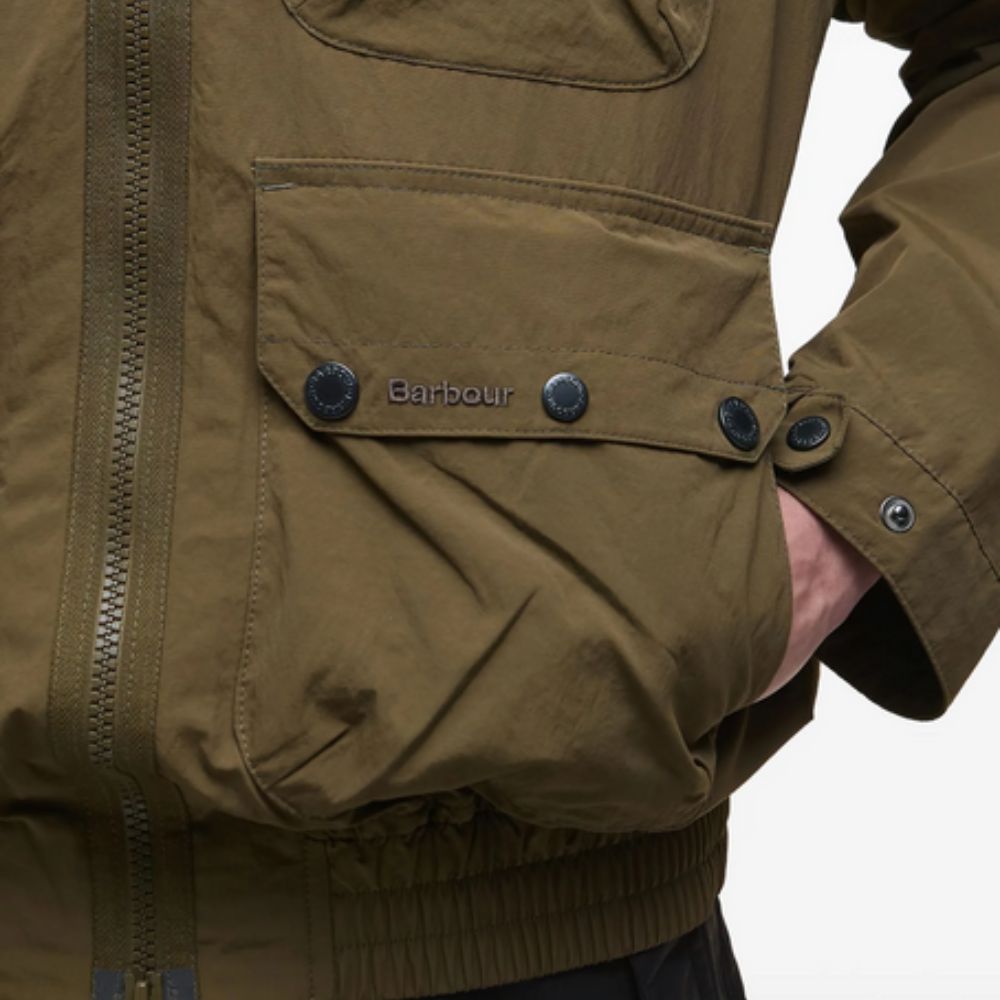 Close-up of a brown jacket with 'Barbour' branding on a white background