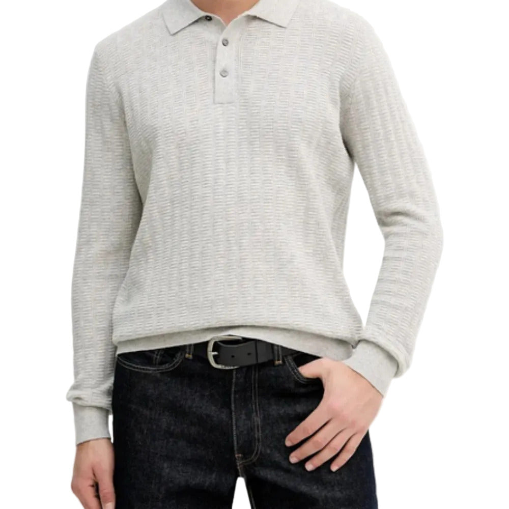 Person wearing a light gray long-sleeve polo shirt over a dark gray sweater with dark jeans on a white background.