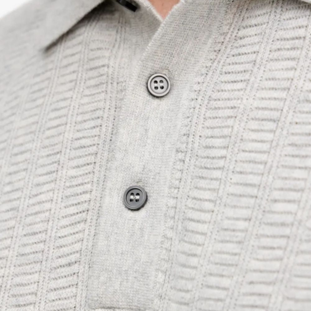 Close-up of a textured gray sweater with buttons