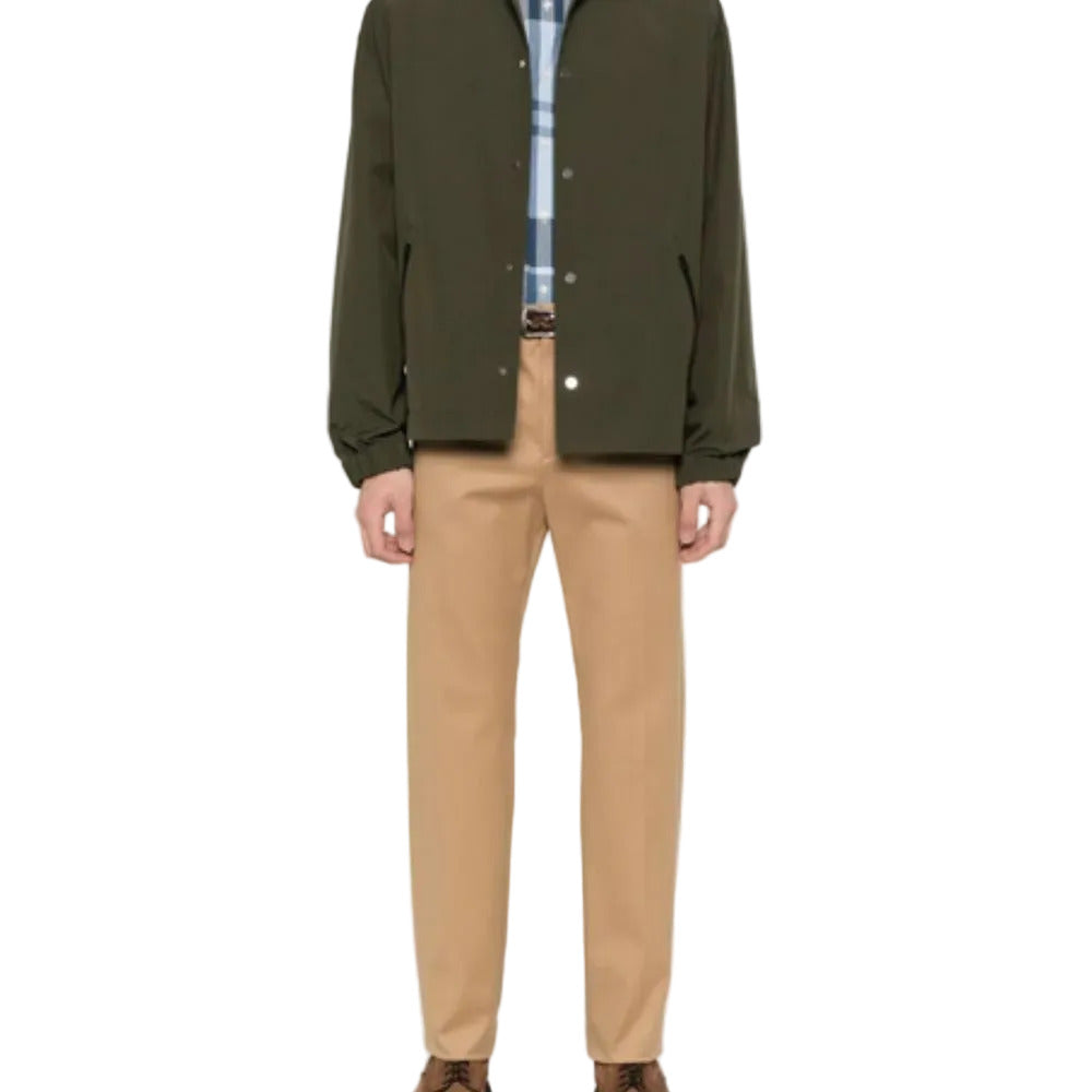 Person wearing a green jacket, plaid shirt, and beige pants on a white background