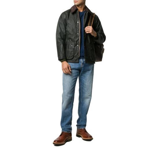 Man wearing a black leather jacket, blue jeans, and brown shoes on a white background