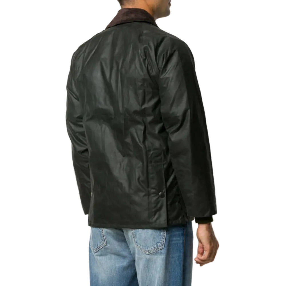 Person wearing a black jacket and blue jeans on a light gray background