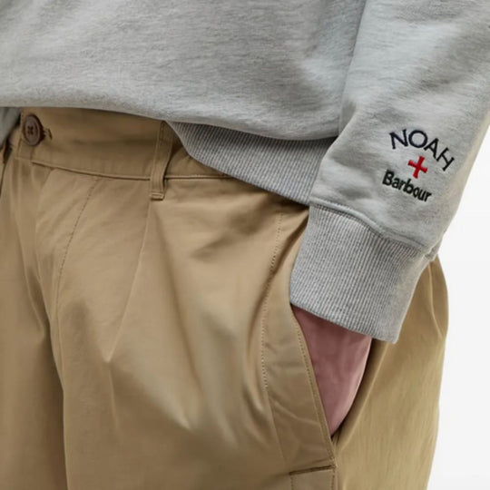 BARBOUR X NOAH Cotton Sweatshirt with 'NOAH' branding worn over beige pants on a white background