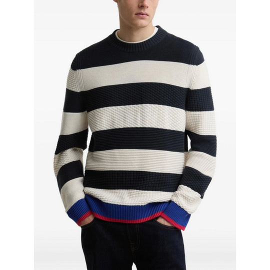 Person wearing a BARBOUR X PAUL SMITH Relaxed Nautical-Style Sweater with a red accent on a white background