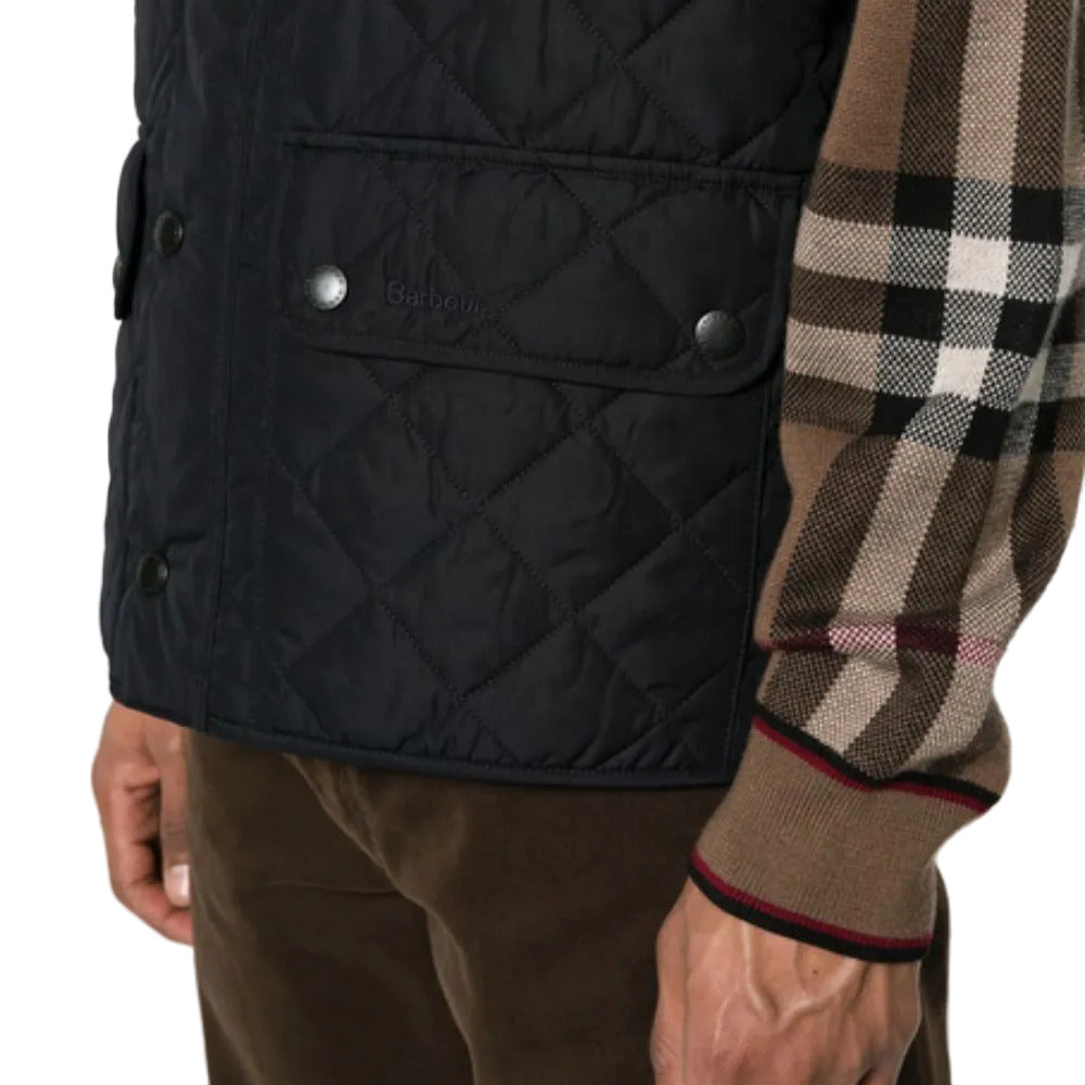 Black quilted vest with a checkered sleeve on a white background