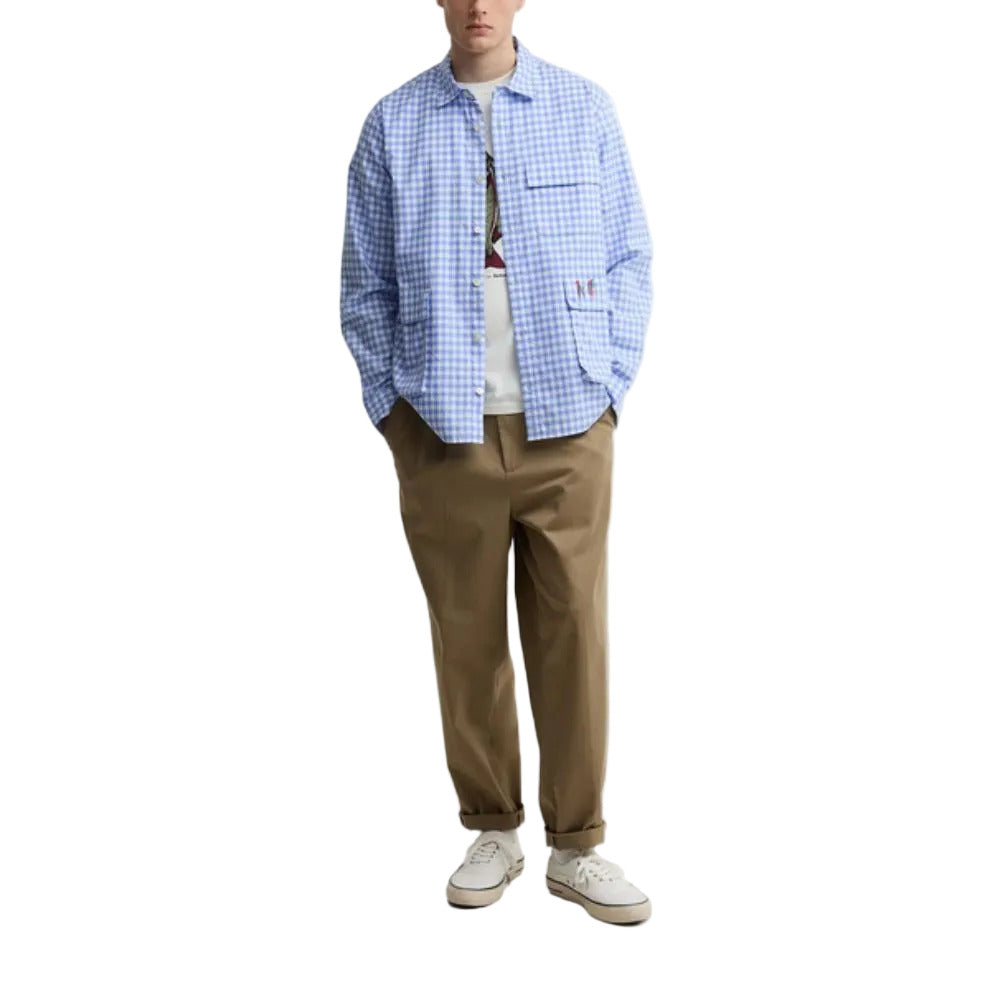 Person wearing a blue checkered shirt, white t-shirt, brown pants, and white sneakers on a white background