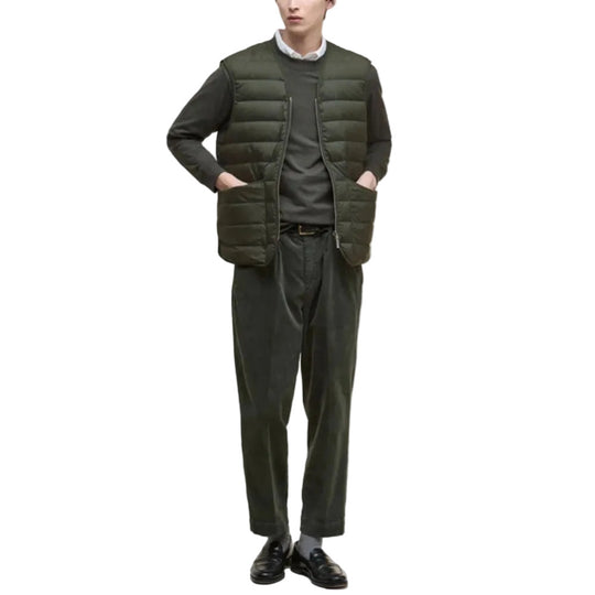 Person wearing a green puffer vest over a sweater with matching pants on a white background