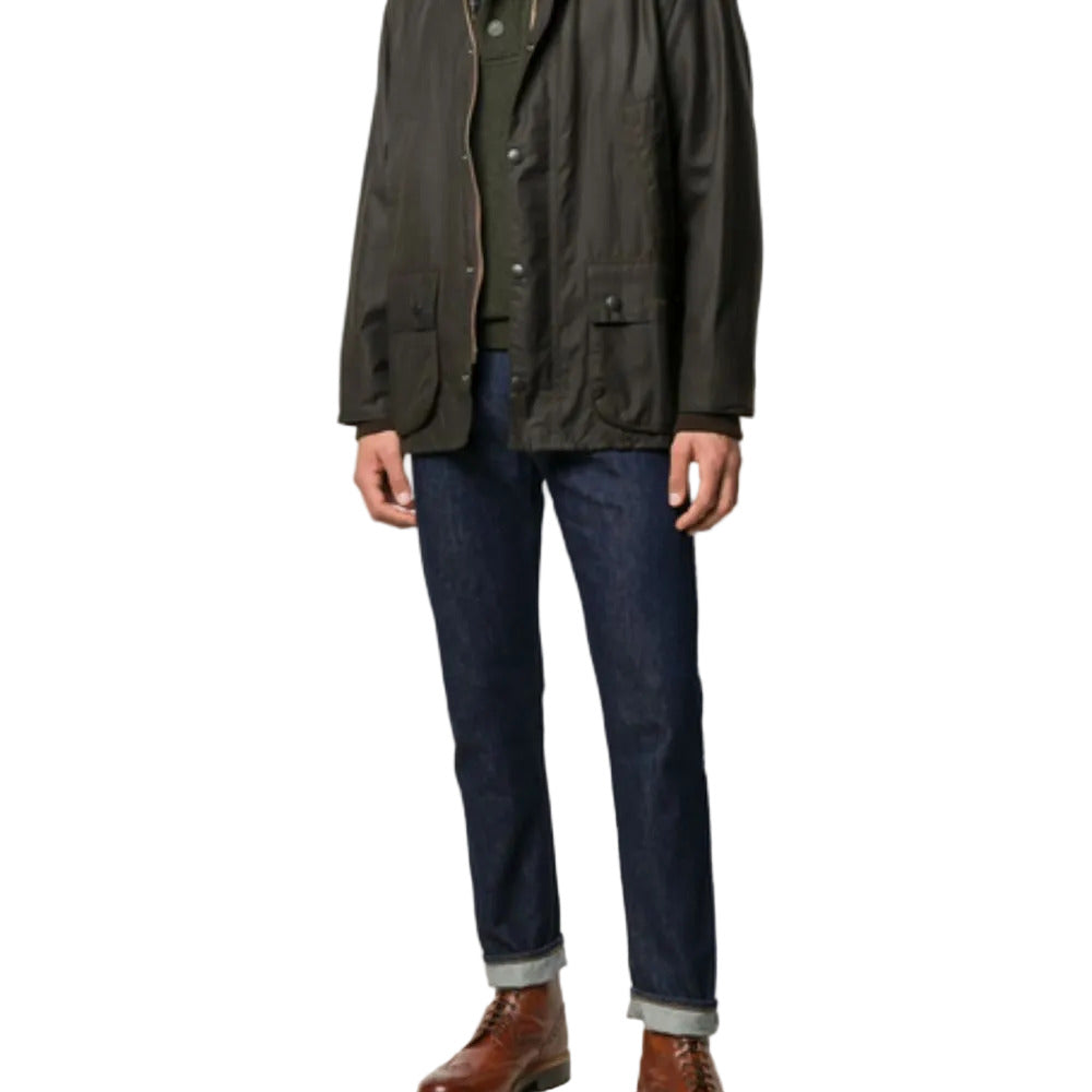 Person wearing a green jacket and dark jeans on a white background