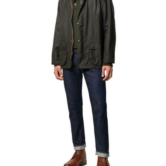 Person wearing a green jacket and dark jeans on a white background