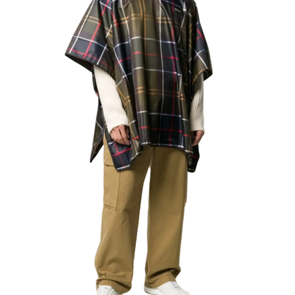 Person wearing a plaid poncho and beige pants on a white background