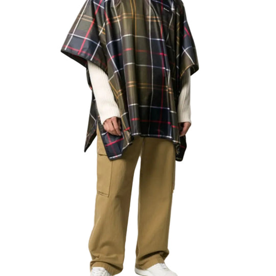 Person wearing a plaid poncho and beige pants on a white background