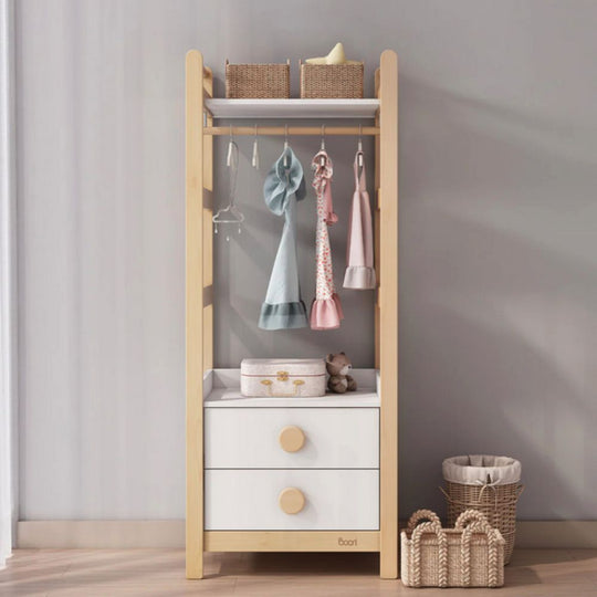 Wooden children's shelf with white drawers, wicker baskets, and hanging items against a gray wall.