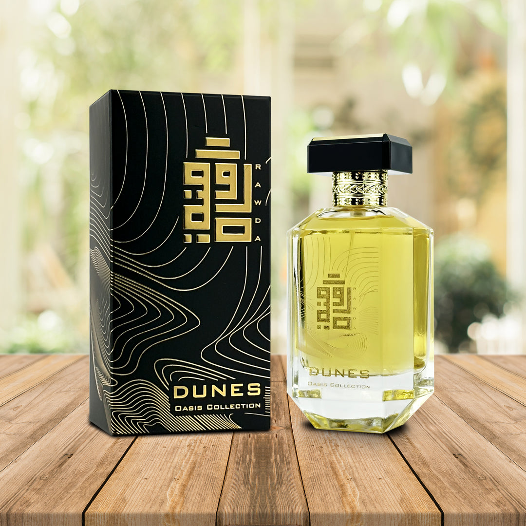 An EDP 100mL bottle of Dunes fragrance by Rawda along with its Box kept on a wooden surface 