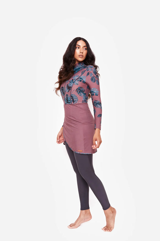 Model wearing sofia mauve print in gray and mauve shade with bluish monstera leaves
