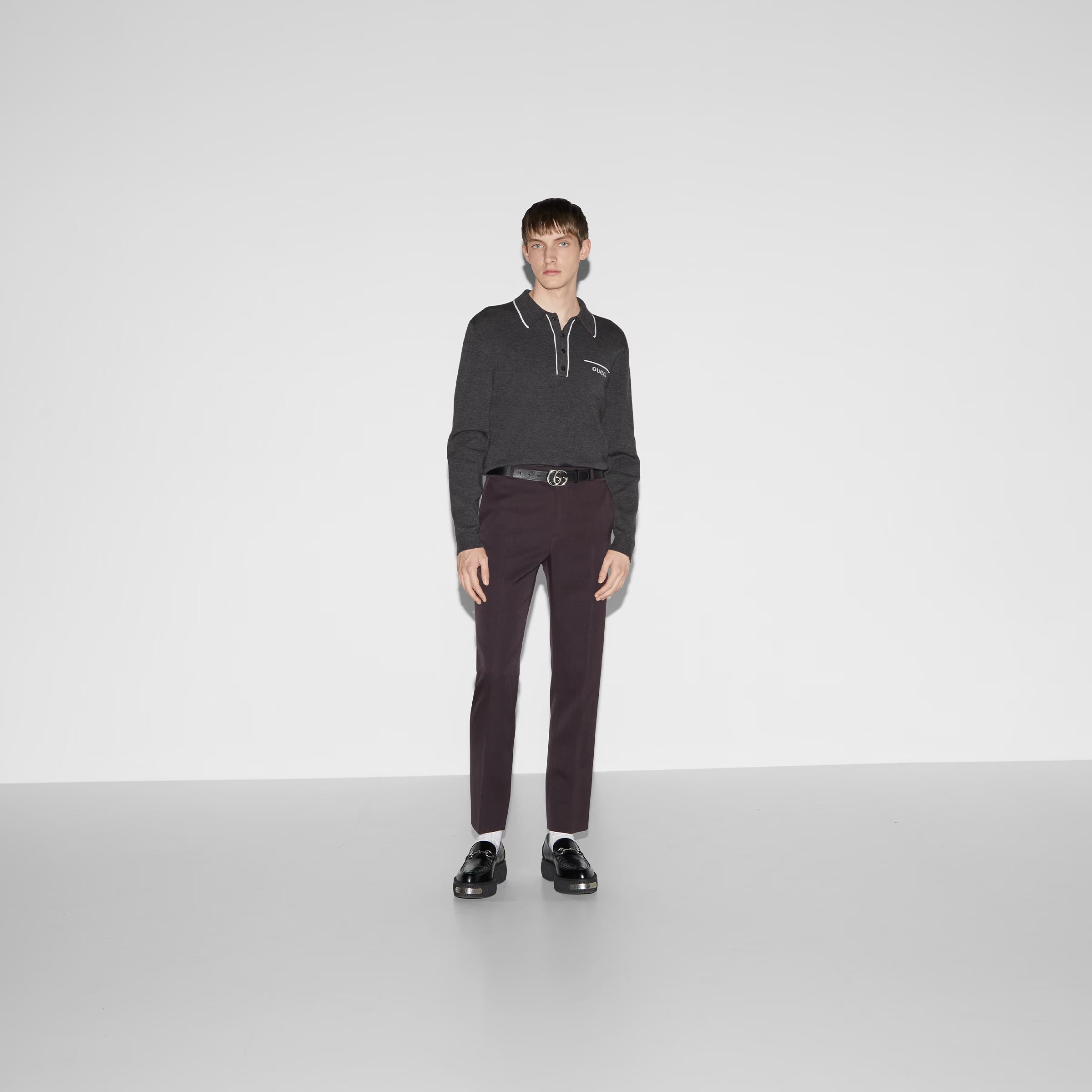 Model wearing gray Gucci polo shirt with brown trousers