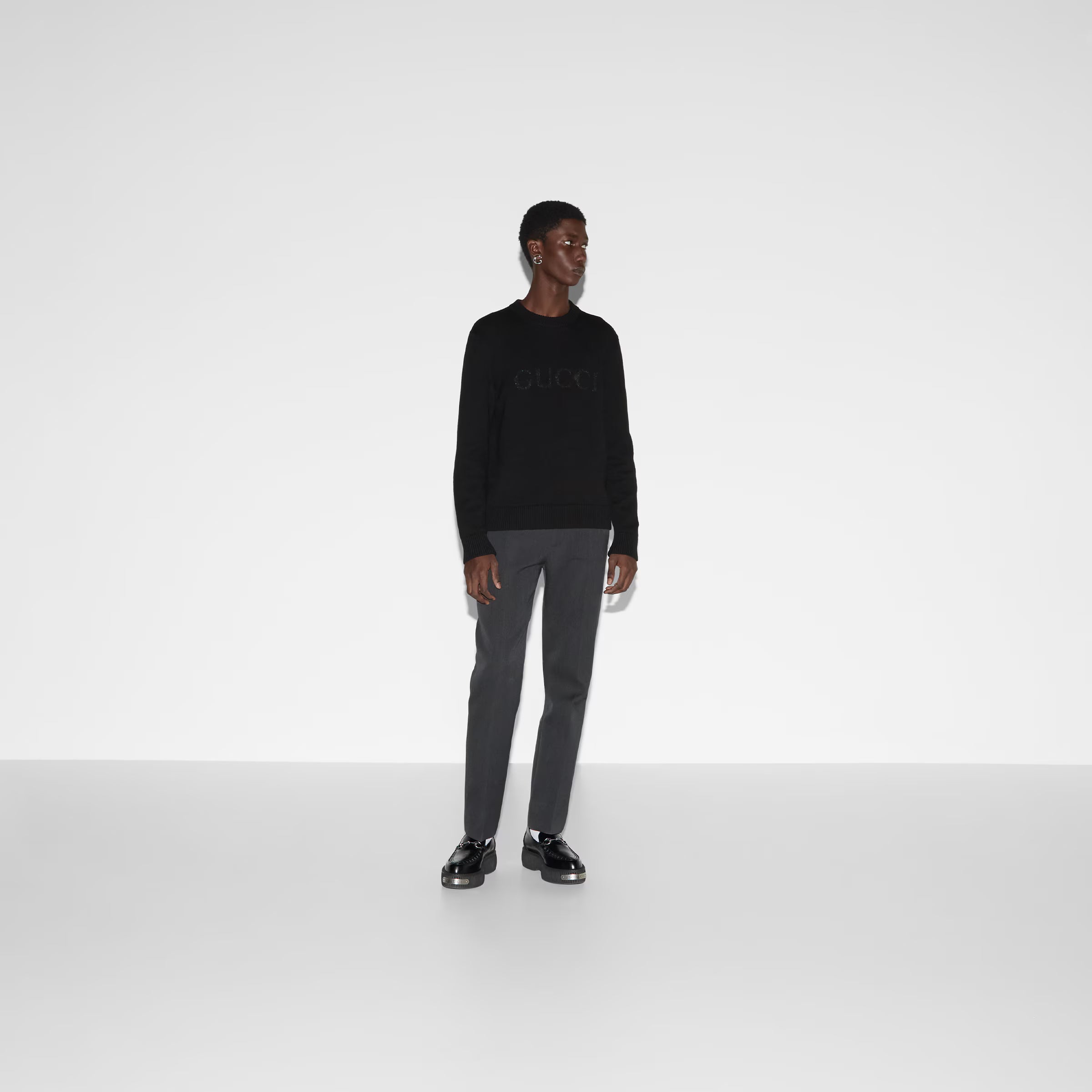 Model wearing Gucci Cashmere Sweater with gray trousers and black shoes