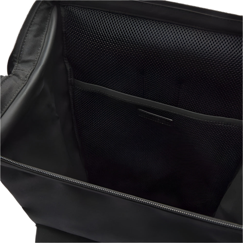 A close-up view inside an open black backpack reveals a zippered main compartment, a mesh pocket, and a flat inner pocket.