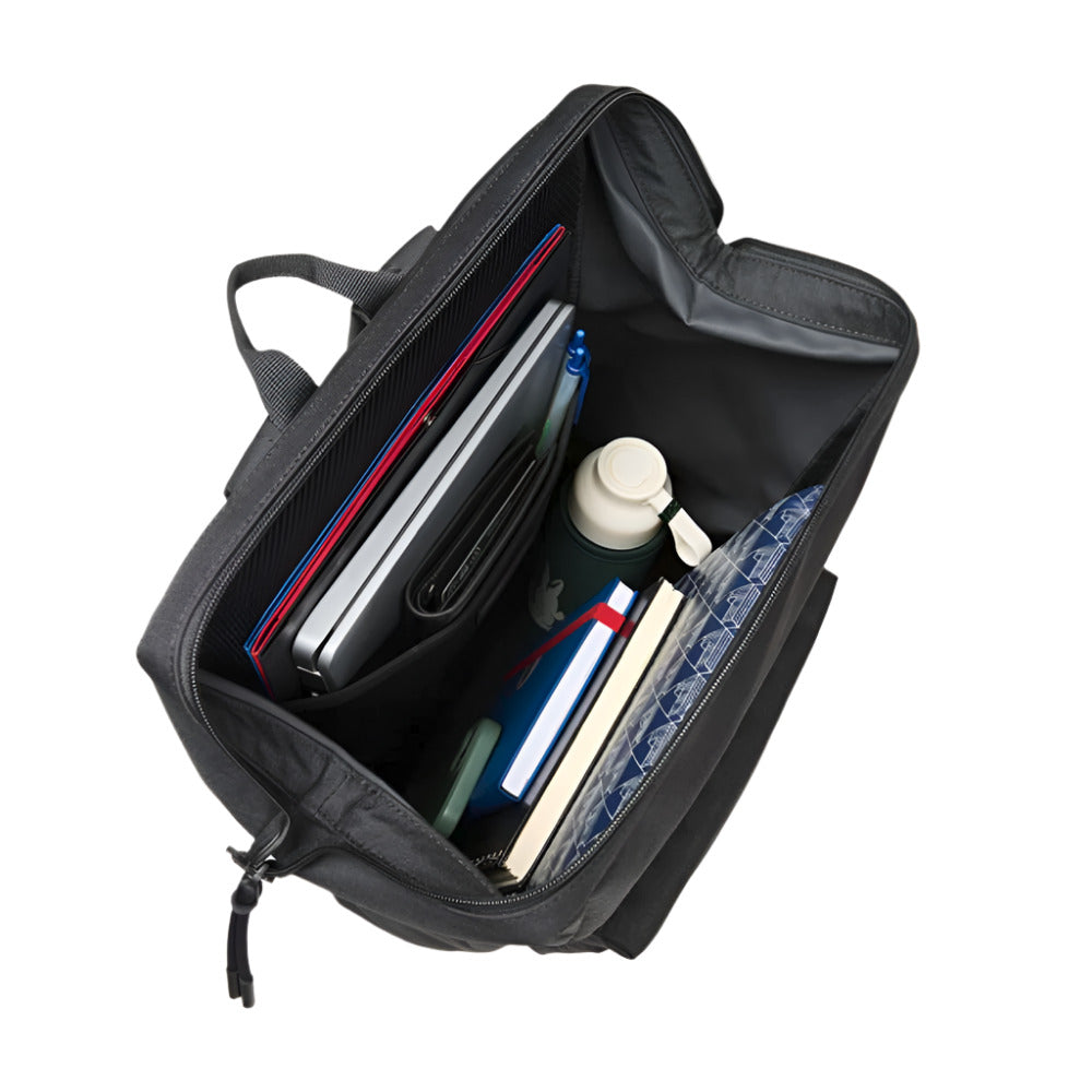 A black backpack is shown from above, open and filled with various items. Inside, a laptop with a red folder behind it is visible in a padded sleeve, alongside a black wallet, a blue pen, a green water bottle, and several notebooks.