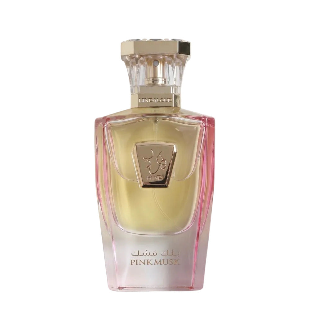 A bottle of PINKMUSK perfume with a faceted clear glass body showing pale yellow liquid inside, pink tinted sides, and a gold cap, centered on a light gray background.