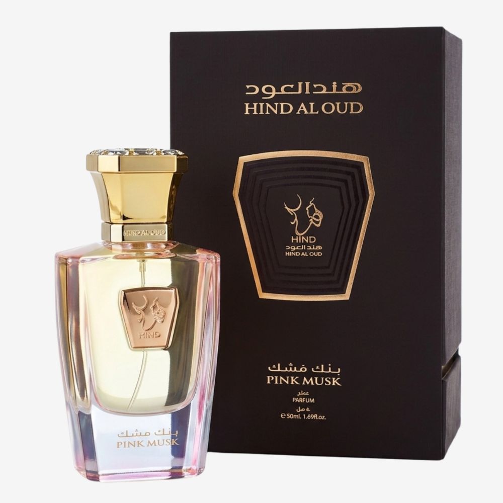A bottle of Hind Aloud Pink Musk perfume with a gold cap and pink-tinted glass, displayed next to its black and gold outer packaging box on a light gray background.