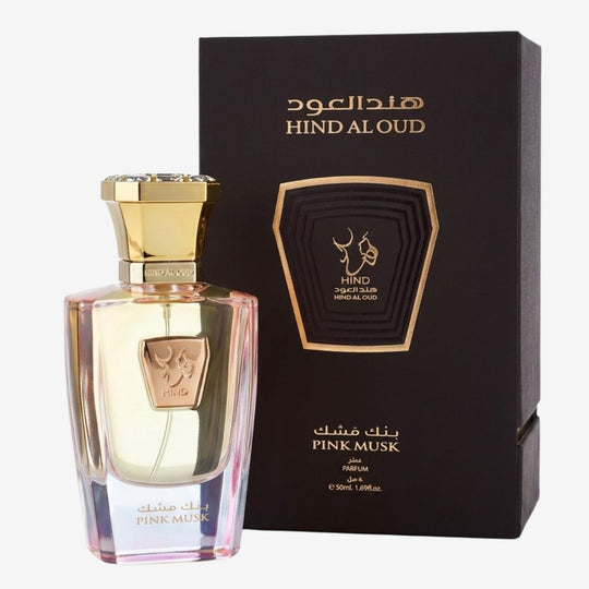 A bottle of Hind Aloud Pink Musk perfume with a gold cap and pink-tinted glass, displayed next to its black and gold outer packaging box on a light gray background.