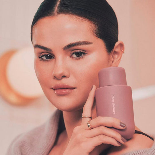 A model with RARE BEAUTY Find Comfort Body Lotion in her hand