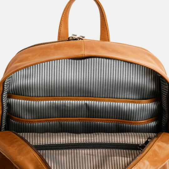 Brown leather backpack with striped interior on a white background