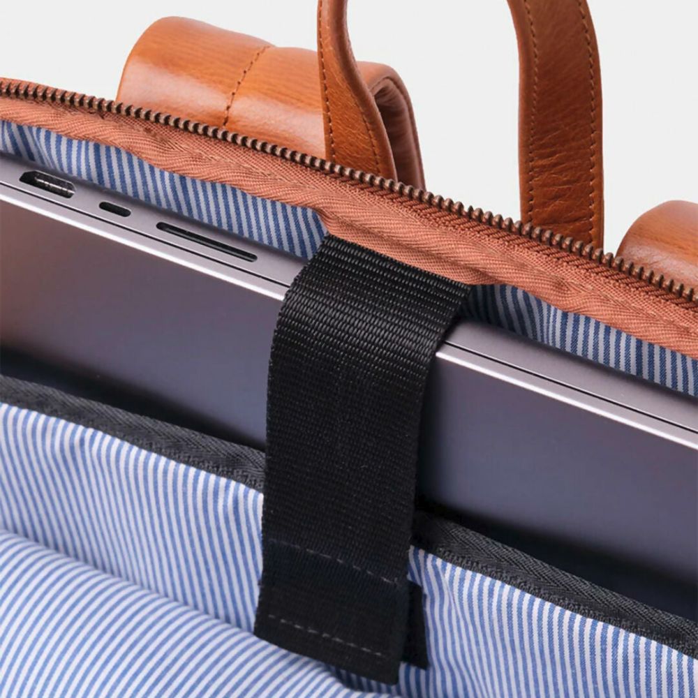 Close-up of a laptop in a bag with a wooden handle and blue striped lining.