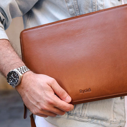 Person holding a Caramel colored Leather Portfolio with 'Ryoko' branding