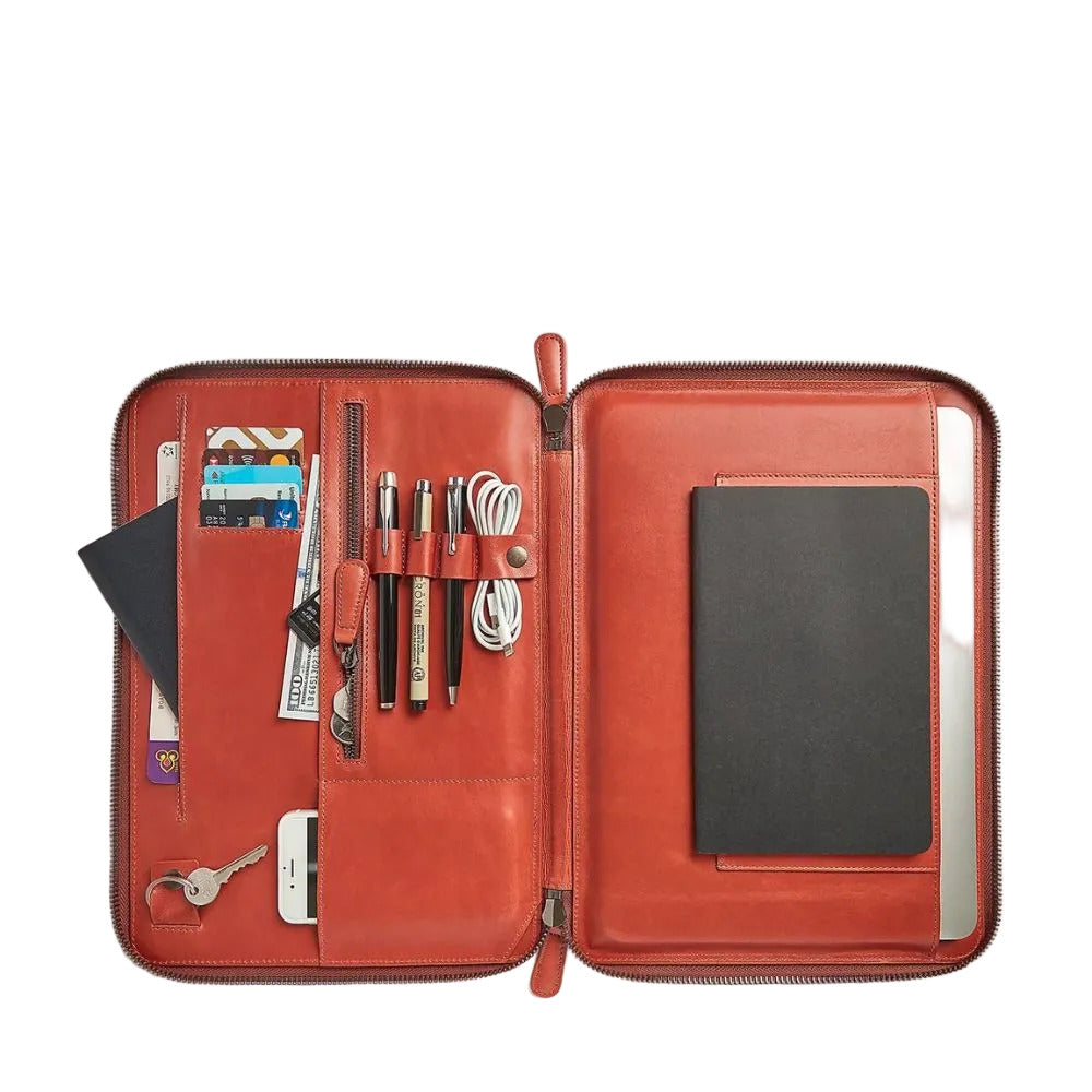 Open red leather organizer with various items on a white background