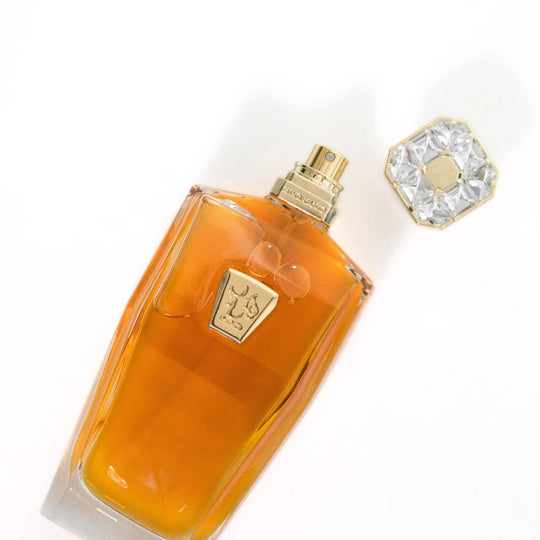 A 183mL Parfum bottle of Sheikh A Exceptional by Hind Al Oud laid on with its cap open and kept besides it