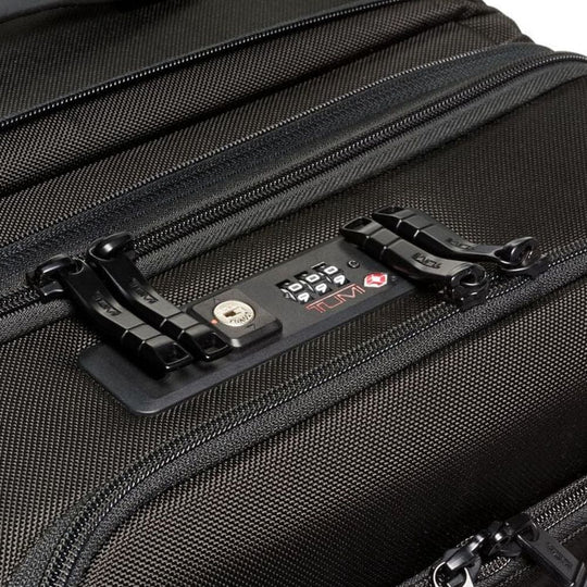 Close-up of a black suitcase with a TSA-approved lock on a white background