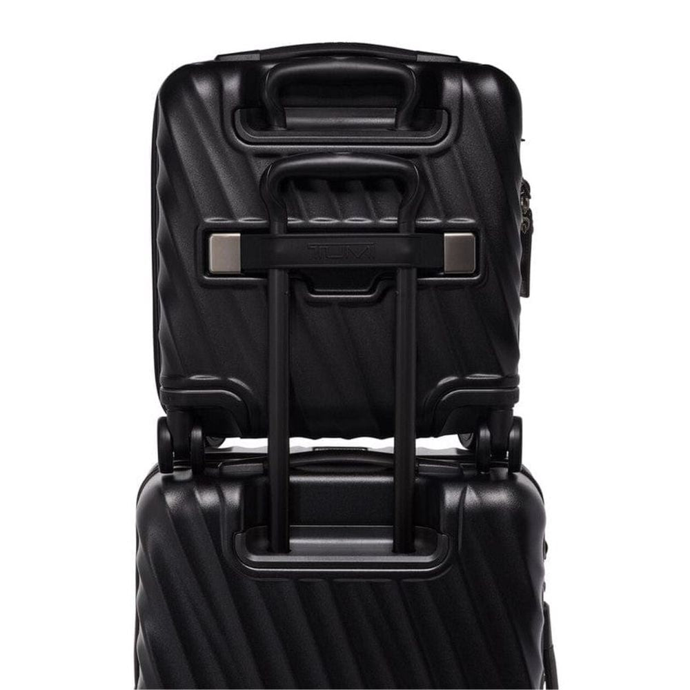 Black suitcase with handle extended on a white background
