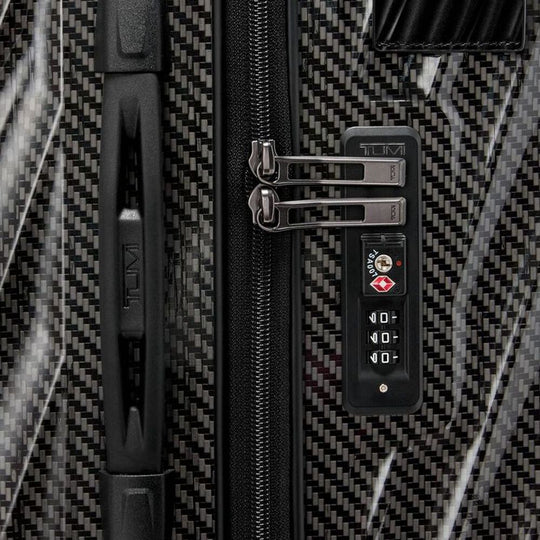Close-up of a suitcase with a TSA-approved lock on a patterned background