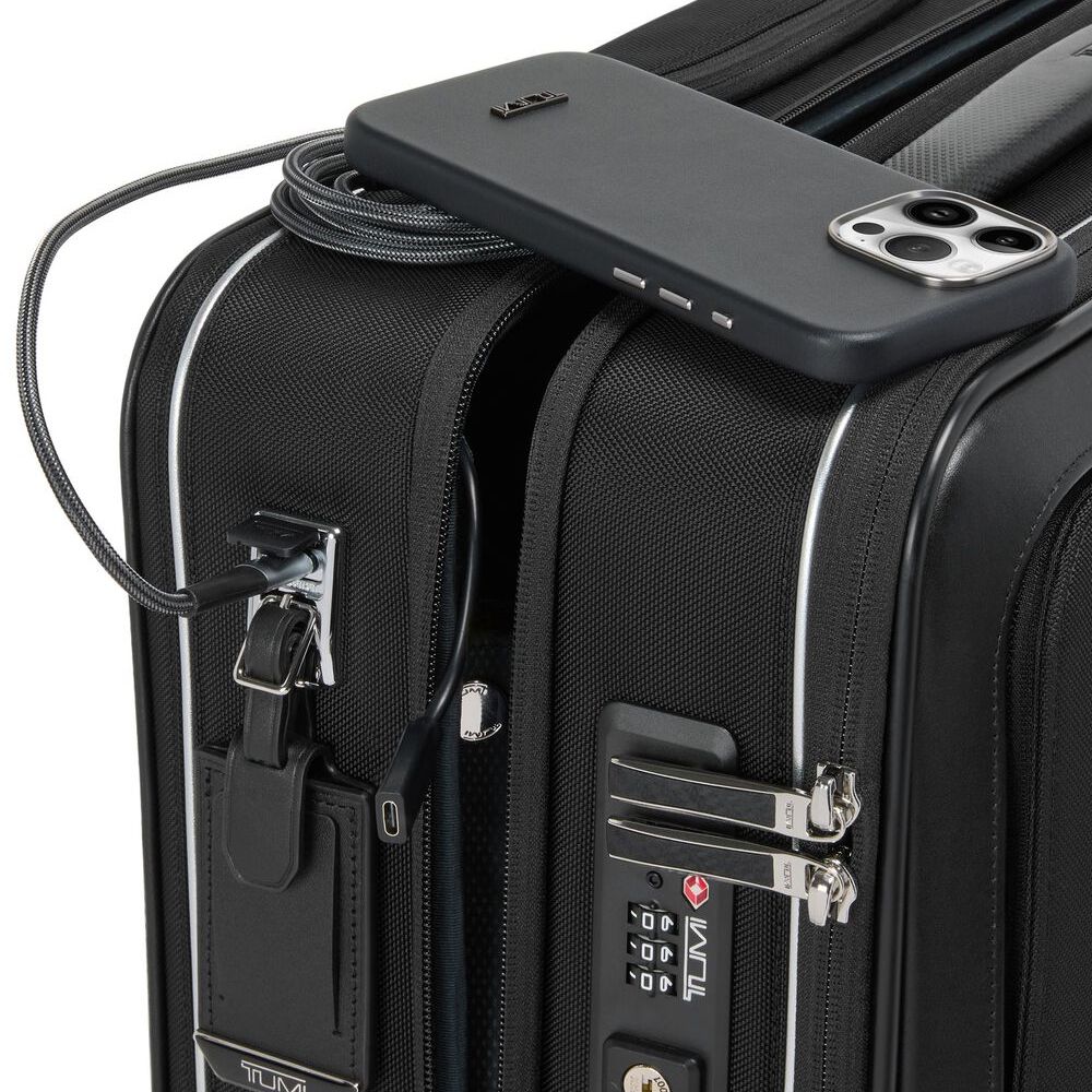 Close up of the combination lock on a Black briefcase with a phone on its top being charged via the USB charging port on the briefcase