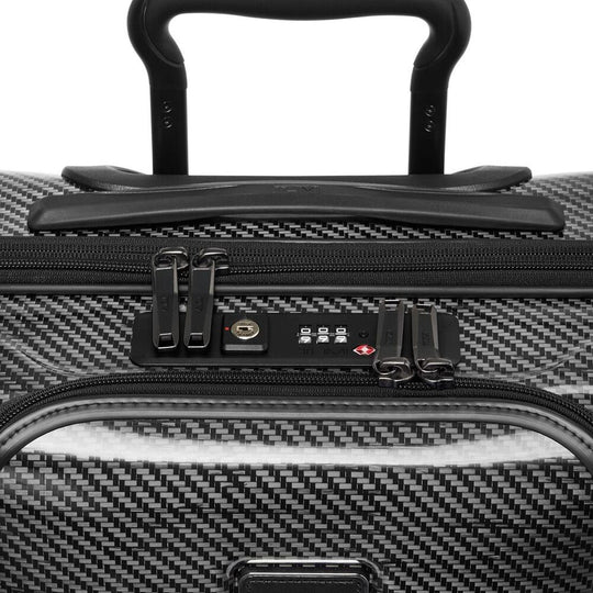 Close-up of a black suitcase handle and security lock on a white background
