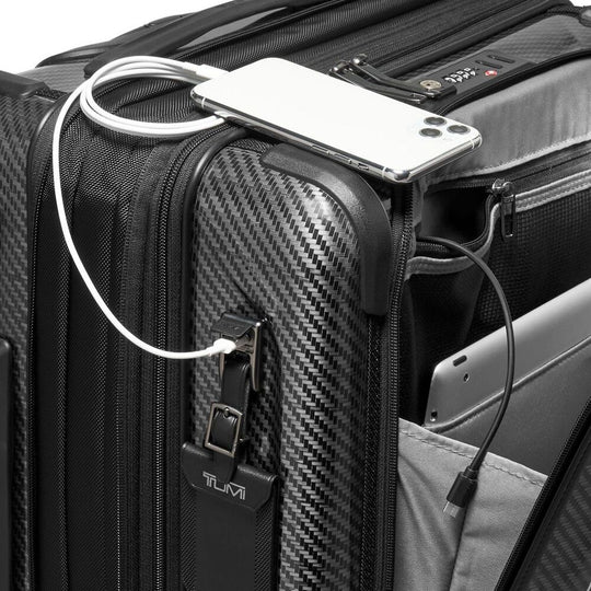 Black suitcase with a phone and cable attached, featuring TUMI branding.