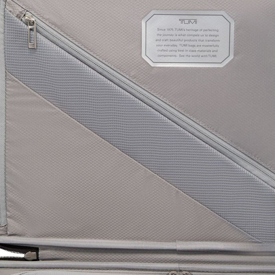 Gray suitcase with TUMI branding and text on a gray background